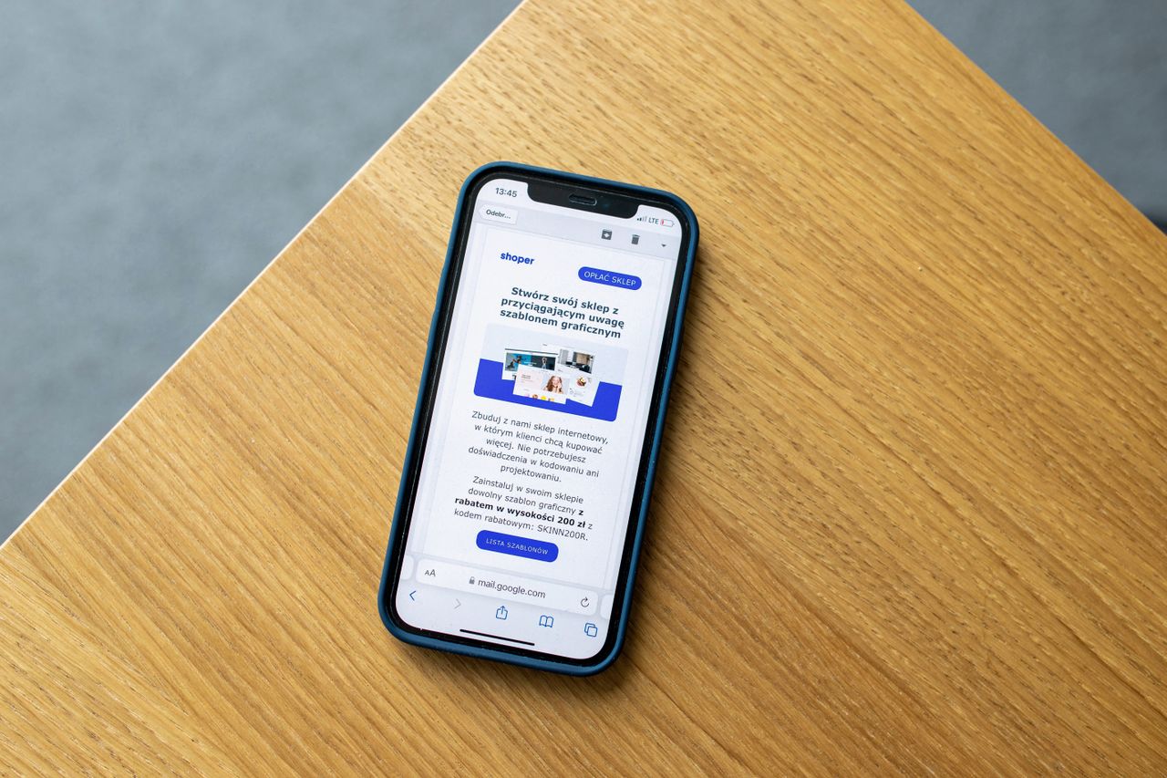 Téléphone mobile affichant une interface e-commerce posé sur une surface en bois, illustrant la technologie du commerce en ligne.